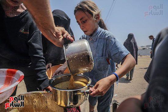 فلسطينيون نازحون داخليًا يتجمعون لتلقي حصة من الطعام من مطبخ خيري فلسطينيون نازحون داخليًا يتجمعون لتلقي حصة من الطعام من مطبخ خيري