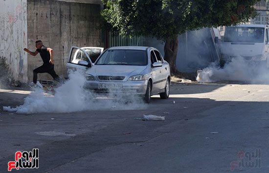 فلسطينى يهرب من قنابل الغاز فلسطينى يهرب من قنابل الغاز