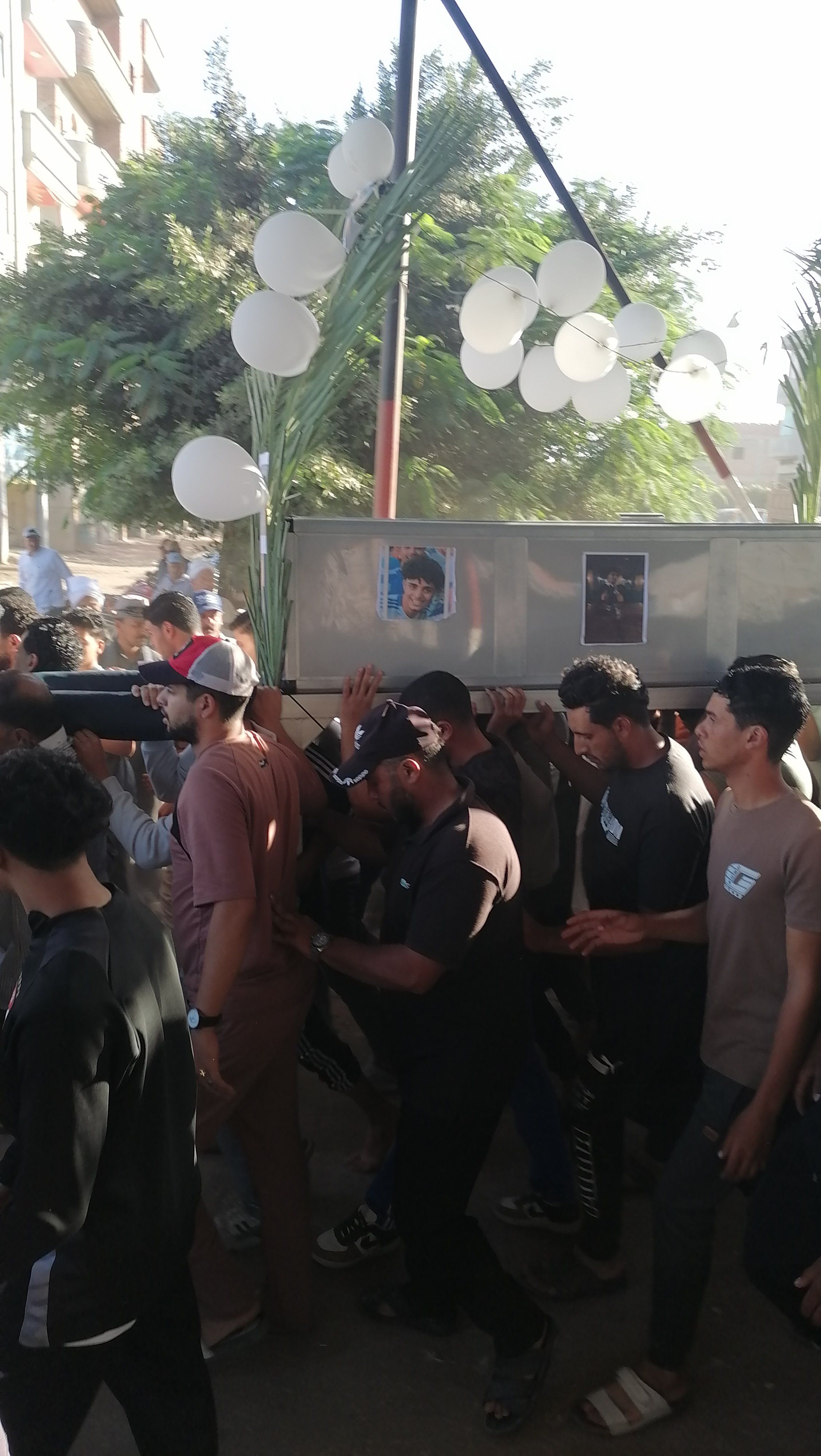نعش الشاب مزين بالجريد والبلالين نعش الشاب مزين بالجريد والبلالين