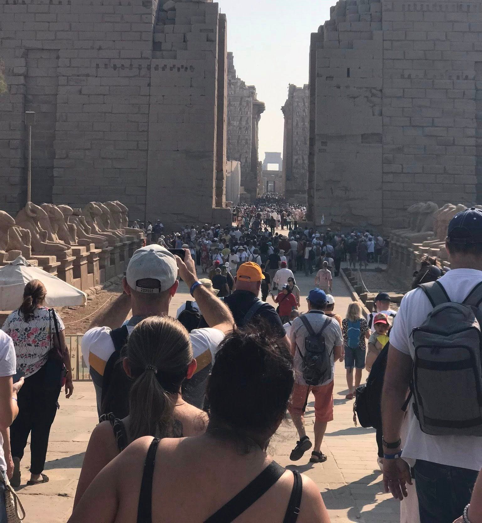 السياح الأجانب من حول العالم سعداء بين جدران وأعمدة معابد الأقصر التاريخية