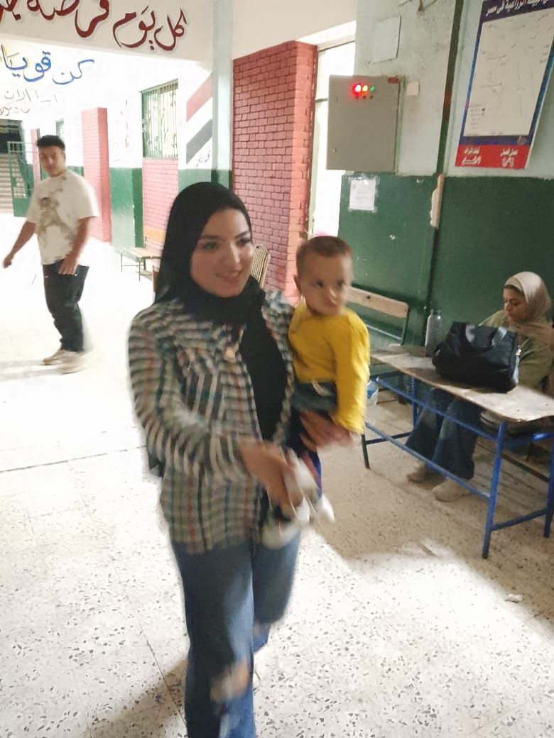 أمراة تحمل طفلها خلال التصويت