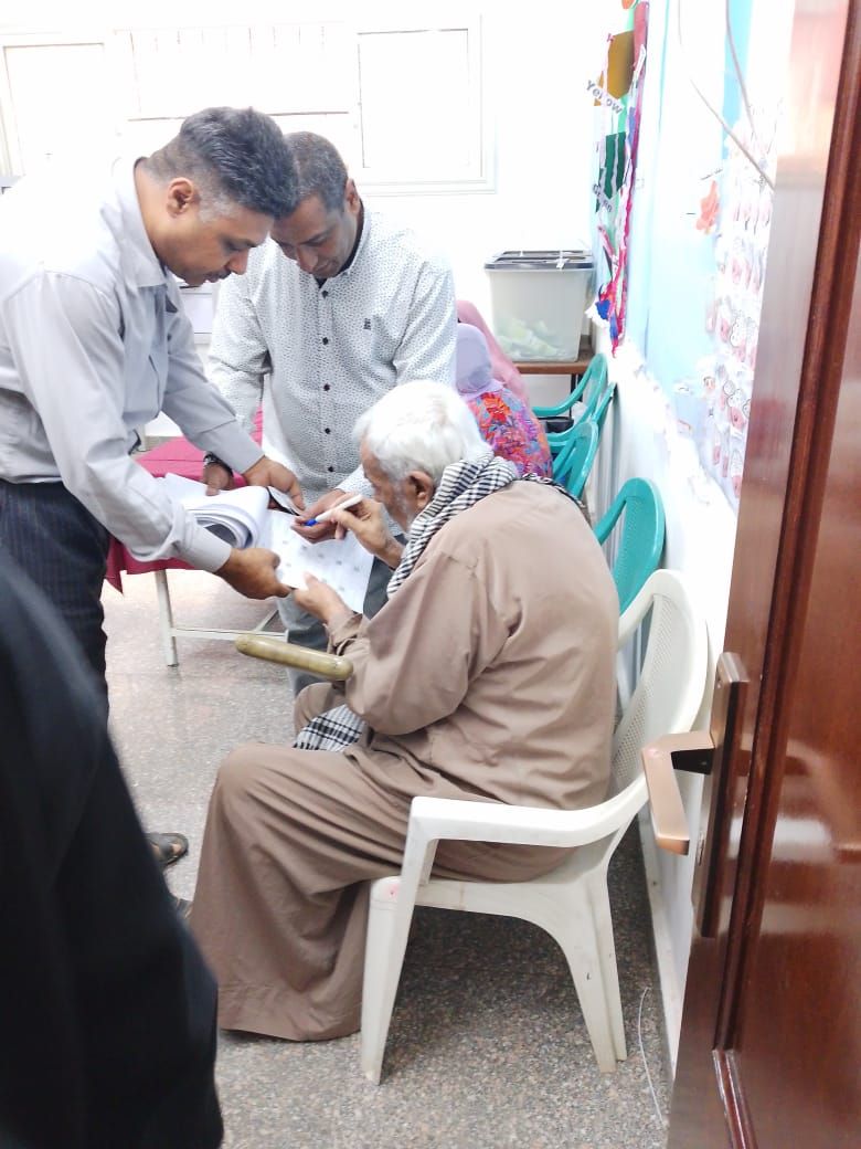 ناخب مسن يسجل اسمه في كشف الحضور بلجنة الانتخابات