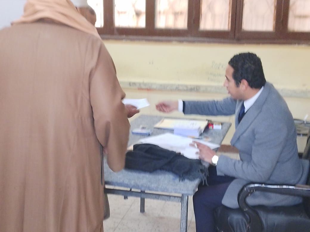 ناخب يتسلم ورقة الاقتراع في انتخابات مجلس النواب 2025