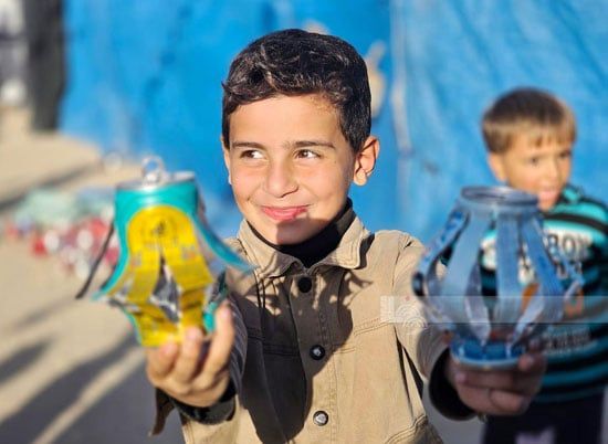 طفل نازح يساعد فى عمل الزينة طفل نازح يساعد فى عمل الزينة