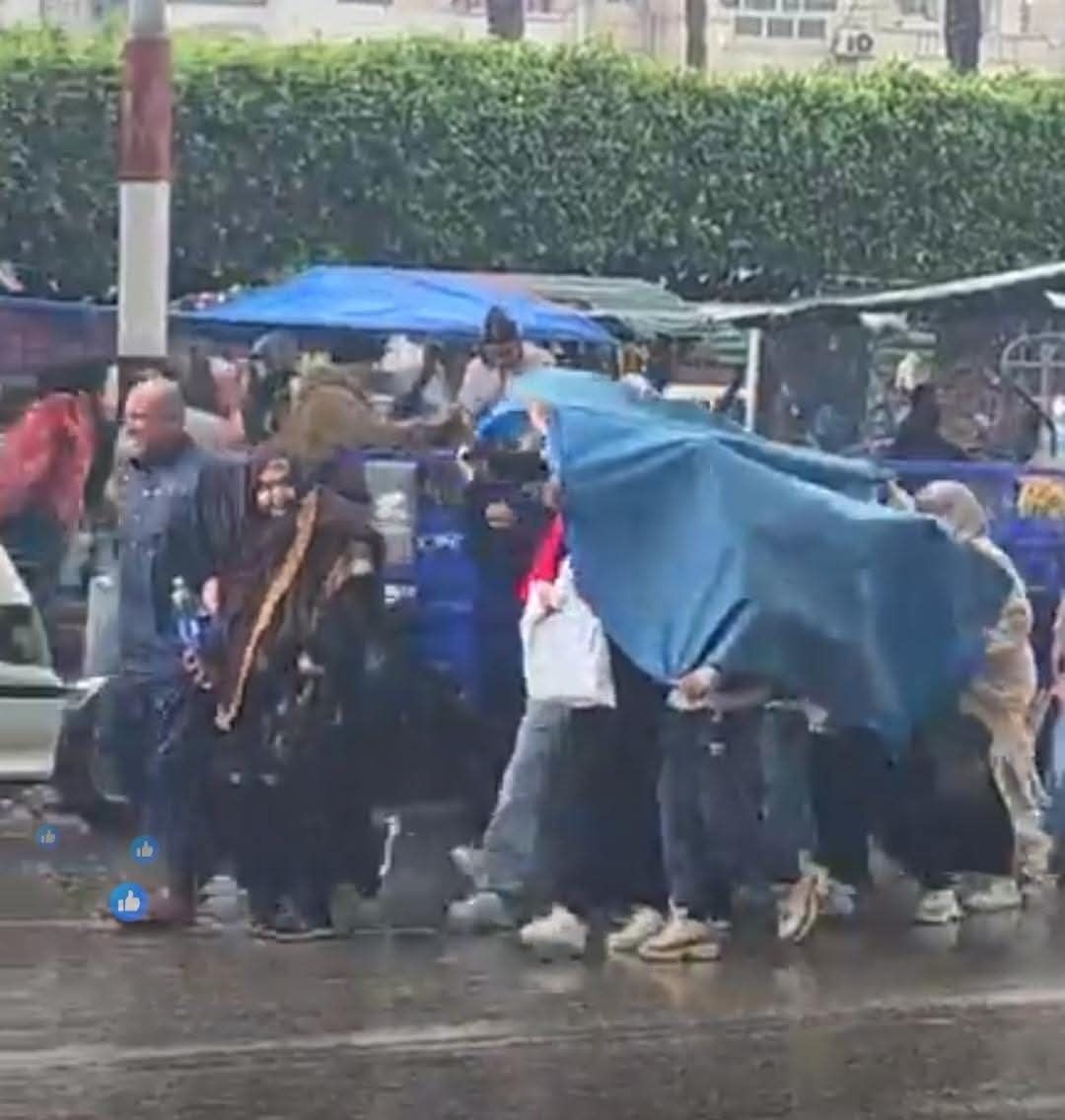 أسر تحتمي بخيمه من الأمطار الغزيرة أسر تحتمي بخيمه من الأمطار الغزيرة