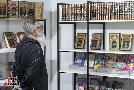 زائر يتفقد الكتب المعروضة زائر يتفقد الكتب المعروضة