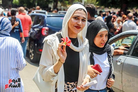 طالبة تحمل وردة بيدها طالبة تحمل وردة بيدها